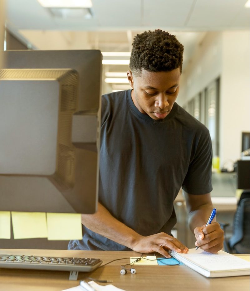 man writing on white paper